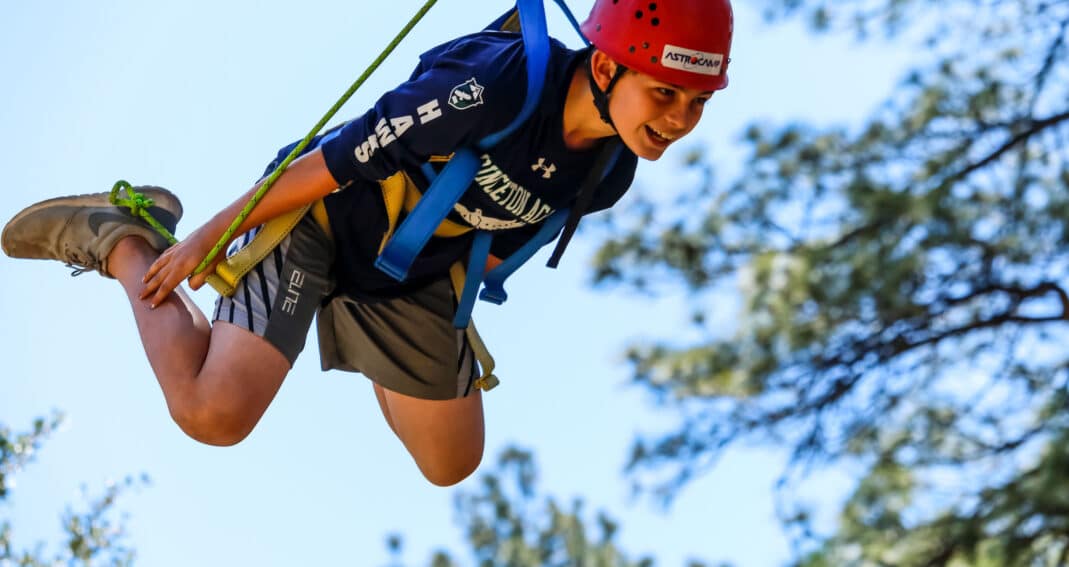 Boy smiling on zipline.