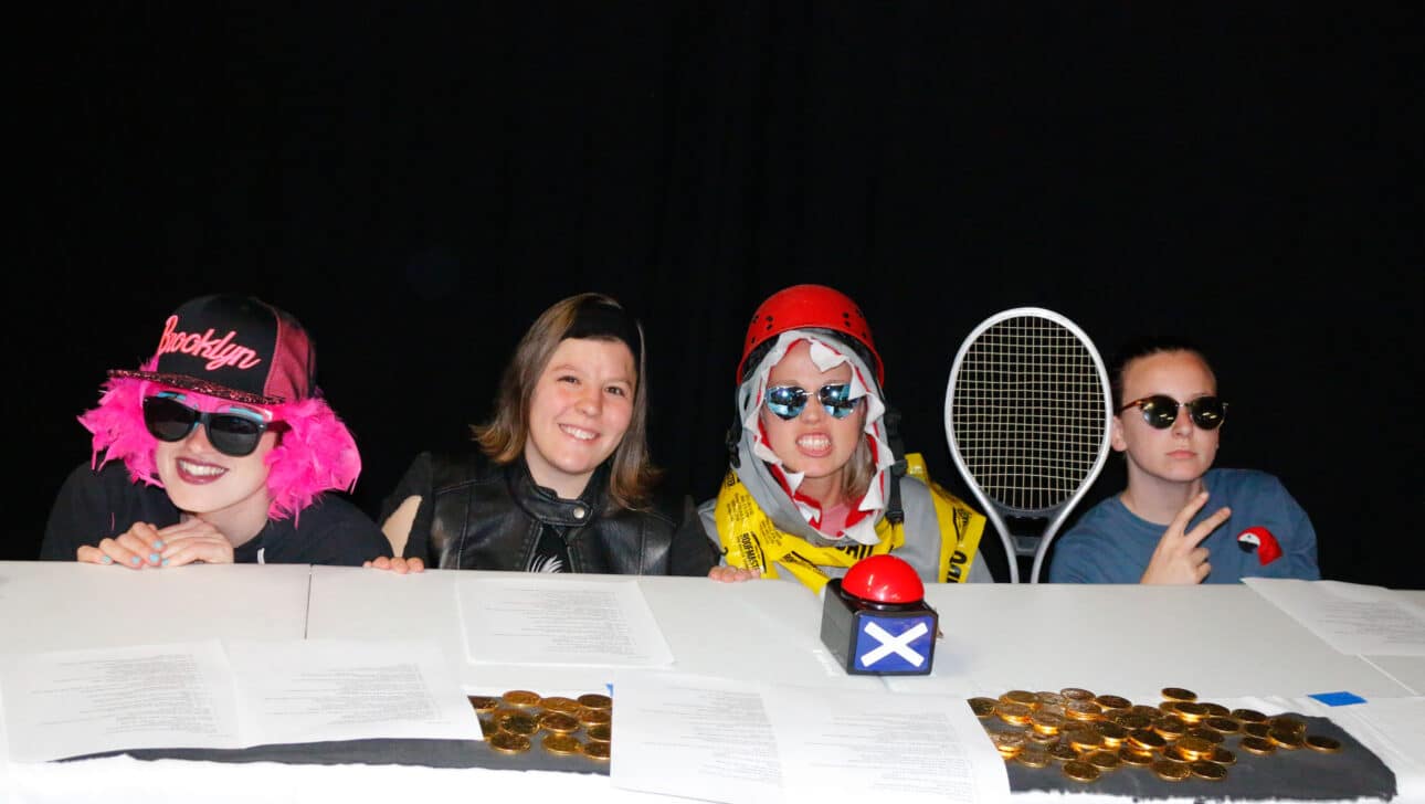 Four staff posing behind table.