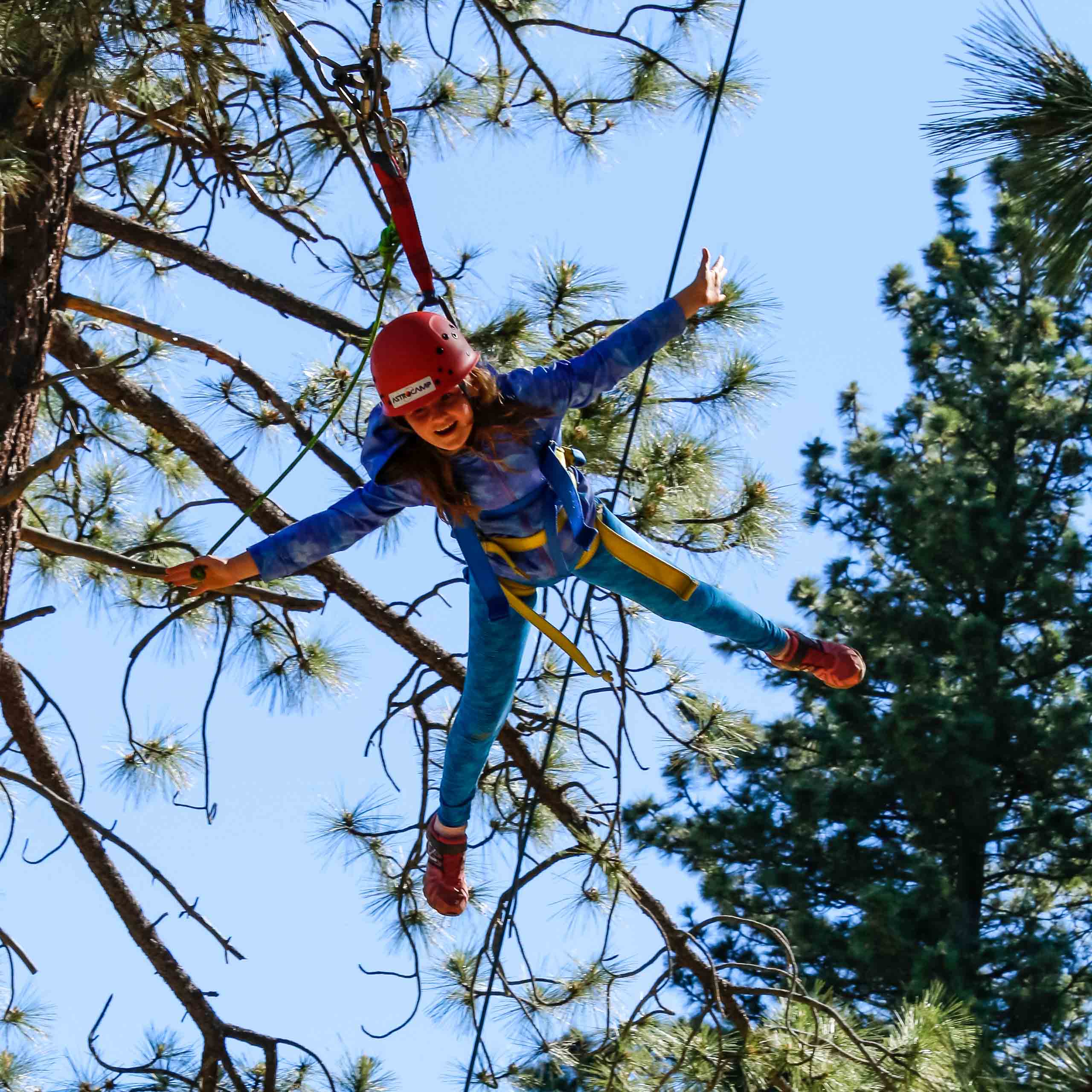 Girl outstretched on zipline.