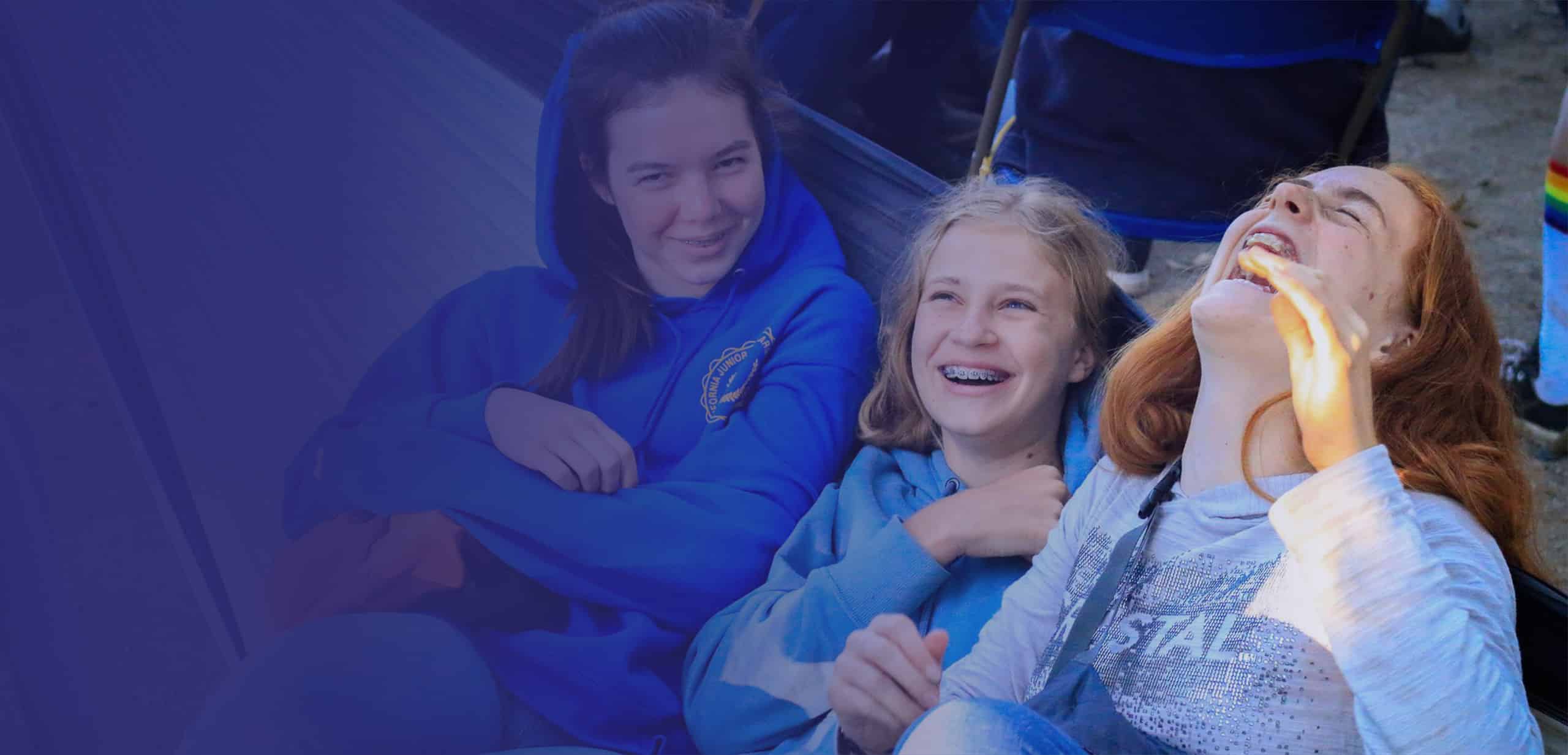 Girls laughing on hammock.