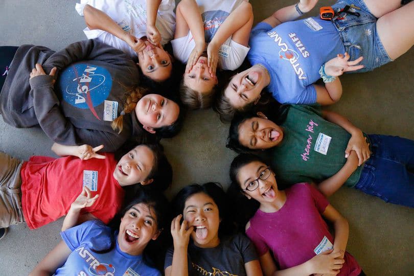 Kids laying in a circle.