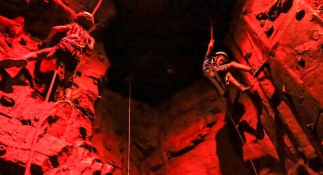 Two kids rock climbing.