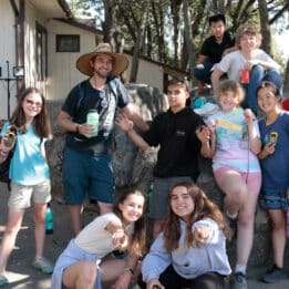 Staff and kids posing on rock.