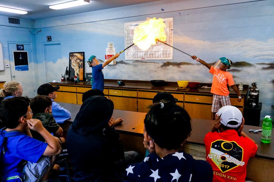 Two kids making fire.