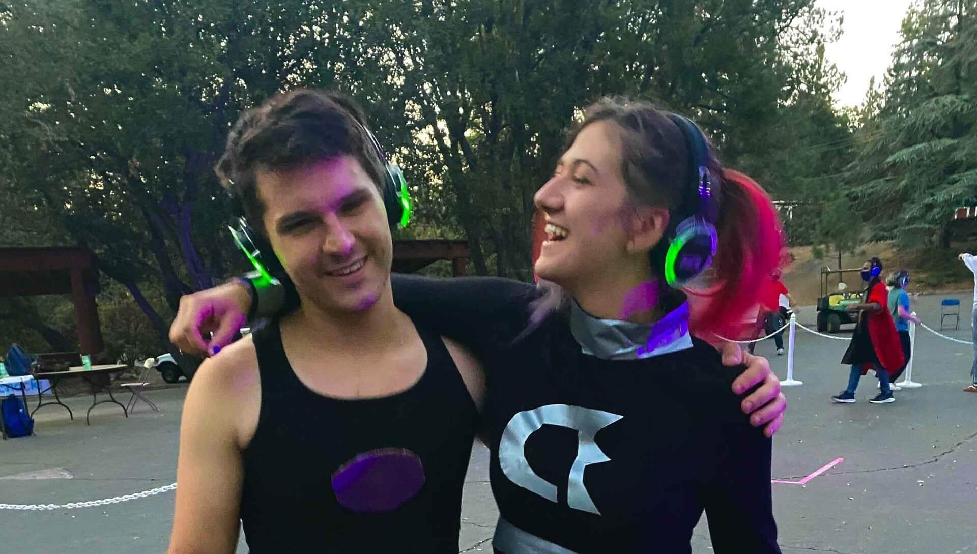 Two people posing with neon headphones.